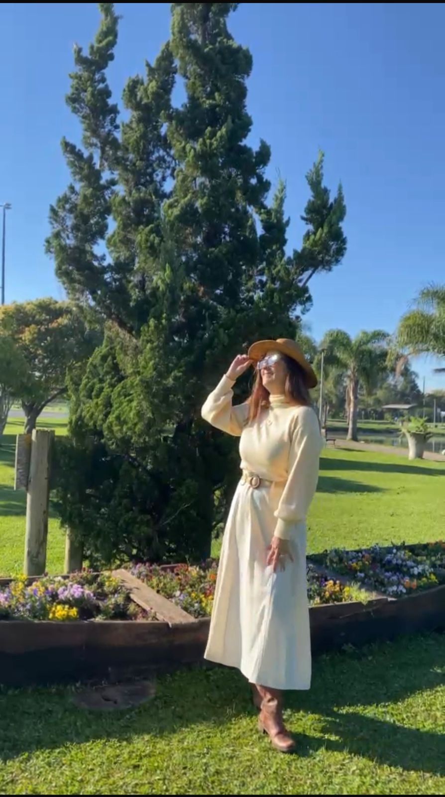 Priscila olhando para o horizonte, de chapéu