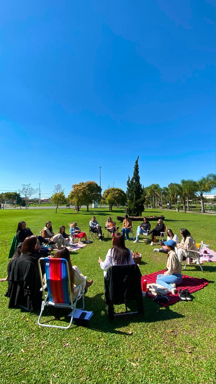 Mulheres reunidas em roda durante um picnic terapêutico